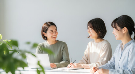 オフィスで談笑・ミーティングする女性たち：打ち合わせ・パソコン・同僚