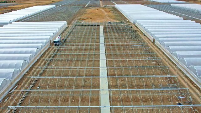 Aerial View of Large Commercial Greenhouse Farm with Mountain Landscape