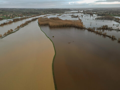 Cadillac-sur-Garonne, France - 20 February 2026: Aerial view of flooded landscapes creating dramatic contrasts between muddy waters and the remaining bare trees.