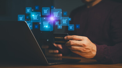 Man holding credit card using laptop for online shopping. E-commerce concept with digital shopping...