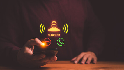 Naklejka premium Hand using smartphone to block scam call. Cyber security protection against fraud, phishing, and hacker threats. Mobile phone user stopping spam.