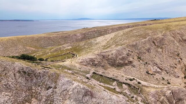 Top down drone view of rocky coastline and natural trails near Ba&scaron;ka on Krk island, Croatia. Concept of adventure travel, hiking exploration and untouched Mediterranean wilderness