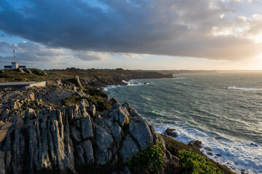 Photographie du Point du Grouin &agrave; Cancale en Bretagne (France), montrant les falaises rocheuses dominant l&rsquo;oc&eacute;an Atlantique. Station d&rsquo;observation et sentier c&ocirc;tier surplombant une mer agit&eacute;e, vagues 