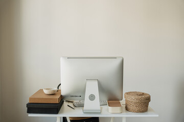 Modern Workspace Setup With Desktop Monitor, Keyboard, Cardboard Boxes, And Wicker Basket