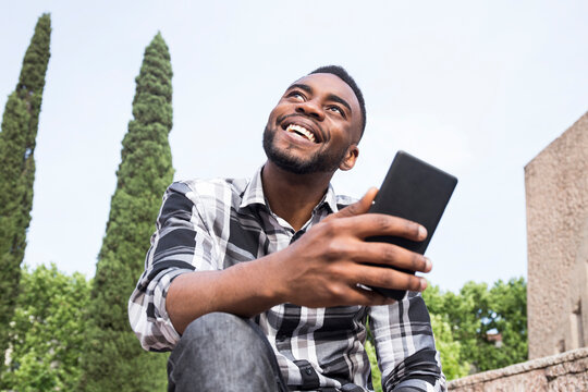Portrait of happy young man with cell phone