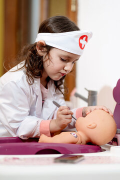 Girl in doctor's costume caring of her doll