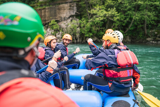 Group of people rafting in rubber dinghy on a river