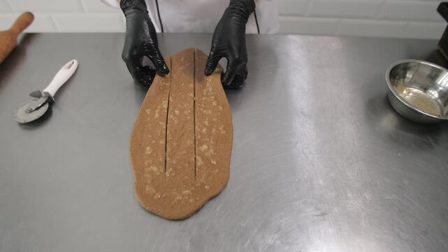 The baker gives the shape of a braid to the dough