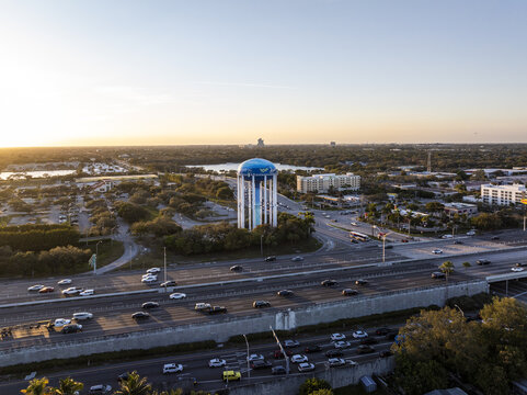 Aerial view of a vibrant water tower gleaming with azure and white hues, standing tall amidst the urban tapestry near the highway, Hollywood, Florida, United States.