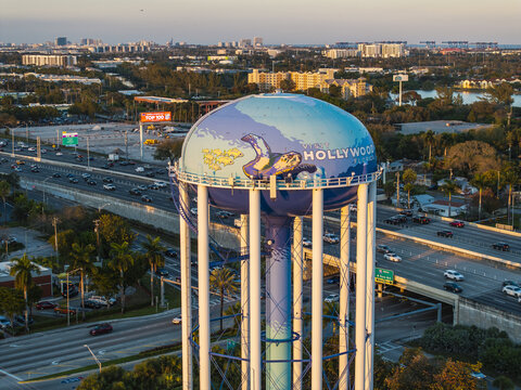 Aerial view of the iconic Hollywood water tower, its mural gleaming against the backdrop of the city skyline and highway arteries, Hollywood, Florida, United States.