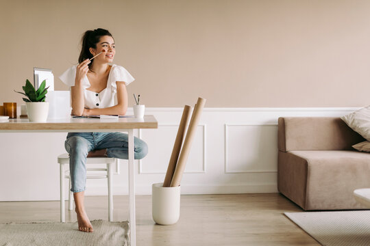 Young woman sitting at table at home