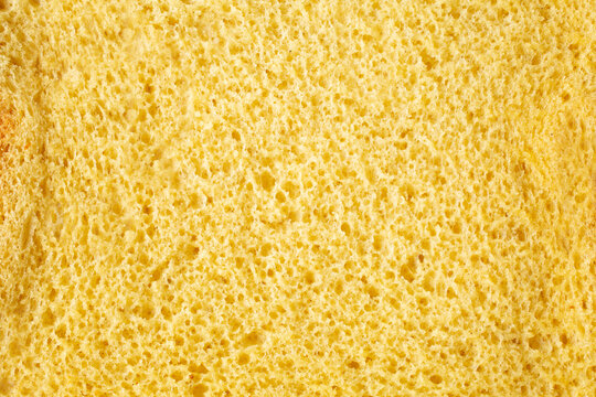 A top down view of a slice of dairy-free, gluten-free brioche bread, as a background.