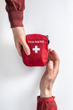 Overhead view of woman handing over first aid kit to man