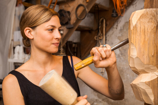 Sculptress carving wooden figure