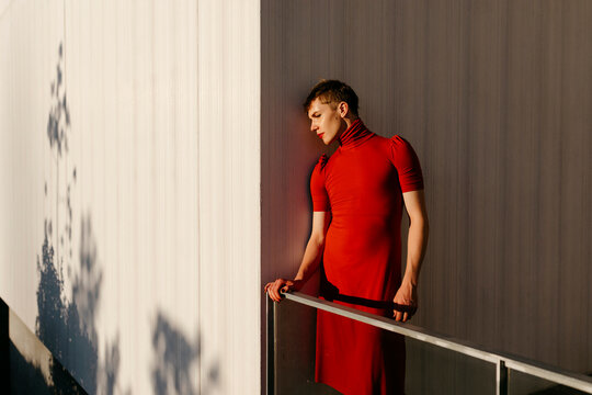 Non-binary male standing by wall during sunset