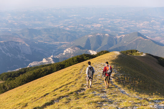Italy, Monte Nerone, two men hiking on top of a mountain in summer