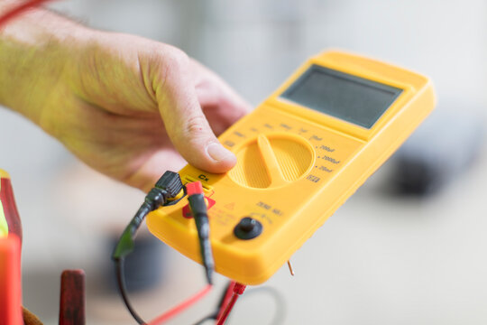 Close-up of electrician holding voltmeter