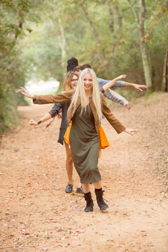 Four happy friends having fun on path in the forest