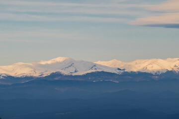 Breath-taking panoramic view of the snow-capped Pyrenees mountains seen from Montserrat. Majestic winter landscape with soft sunset light over the peaks in Spain.