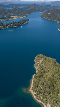 Aerial view of the tranquil blue waters surrounding lush green islands, creating a serene vista of natural beauty, San Carlos de Bariloche, Rio Negro Province, Argentina.