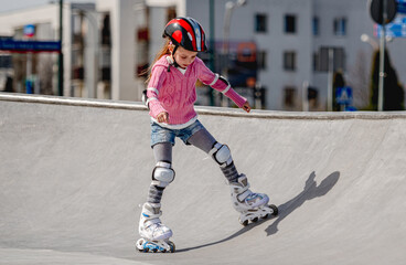 Little Girl Roller Skating In A Helmet At The Skatepark In Spring