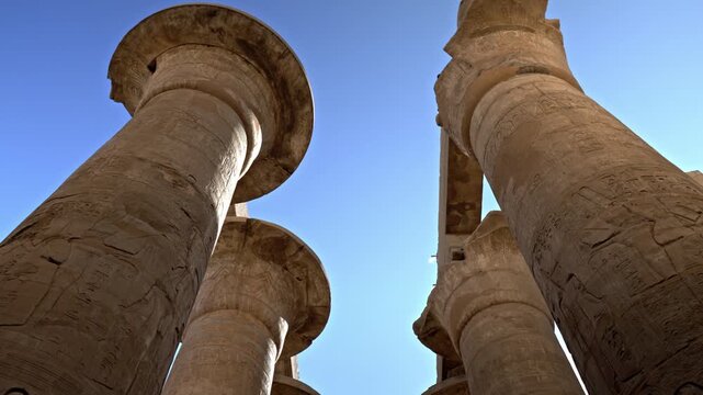 Located within the Karnak Temple Complex in Luxor, Egypt, this low-angle shot looks up at the massive flared capitals of the central nave in the Great Hypostyle Hall.
