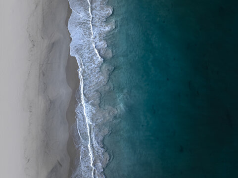 Aerial view of where the foamy turquoise waves meet the pale sands along the coast, City Beach, Western Australia, Australia.