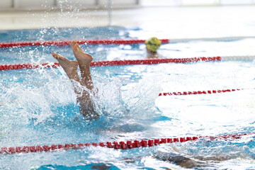 Swimmer's legs creating splash in swimming pool water