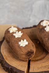 Fototapeta premium a black potato cake lies on a serving paper, a sweet classic cake made from butter and a large amount of cocoa mixed with sponge cake and cognac