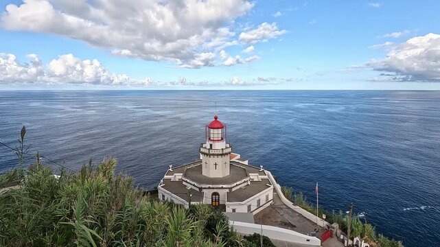 Farol do Arnel lighthouse overlooking the open Atlantic from the cliffs of Nordeste, Sao Miguel Island, Azores