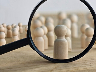 Fototapeta premium Job seekers through a magnifying glass. Meticulous hiring, talent scouting, and strict selection criteria. Recruitment, labor market