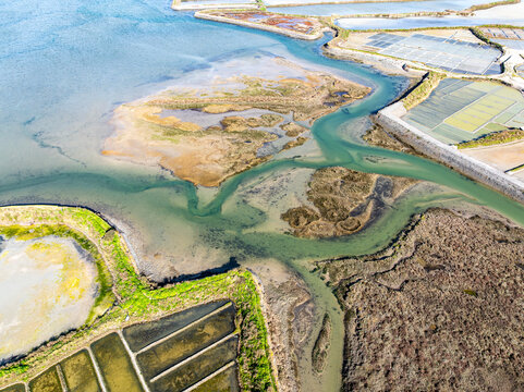 Aerial view of the intricate network of waterways and salt marshes, where the earthy browns meet the cool blues, Guerande, Bretagne, France.