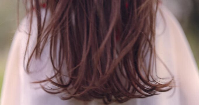 Happy little girl in vintage ethnic folklore dress running through blossom orchard in springtime
