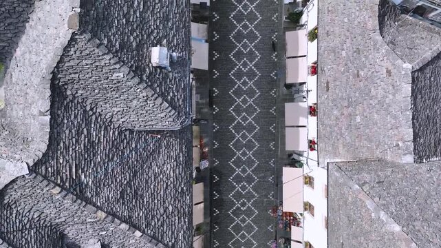 Top Down View of Gjirokast&euml;r&rsquo;s Cobblestone Street.  A vertical aerial view capturing the patterned cobblestone street of Gjirokast&euml;r framed by traditional stone rooftops. The geometric design and hist