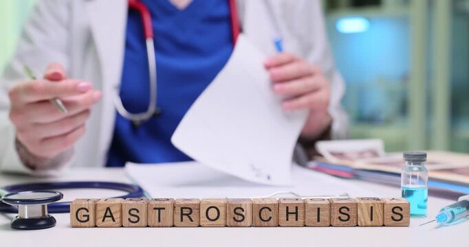 Gastroenterologist writes detailed recommendations for patient. Wooden cubes form medical term Gastroschisis indicating condition under consideration