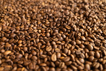 Fototapeta premium Close-up macro shot of roasted coffee beans, creating a rich textured background for your design