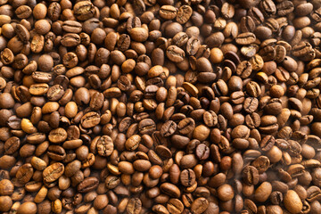 Close-up overhead view of roasted coffee beans, showcasing their rich brown color and texture