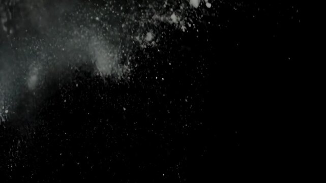 White Powder Explosion on Black. Realistic white dust or flour burst with particles scattering across a dark background. High-speed debris effect for VFX.