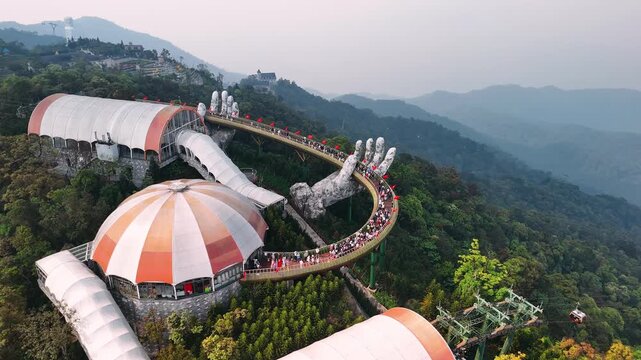 Aerial view of the golden bridge in ba na hills, a popular tourist destination in da nang. People are walking along the walkway
