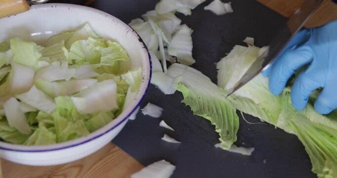 Chef cutting Chinese cabbage bai cai with sharp angle shape using wide Asian style cleaver knife