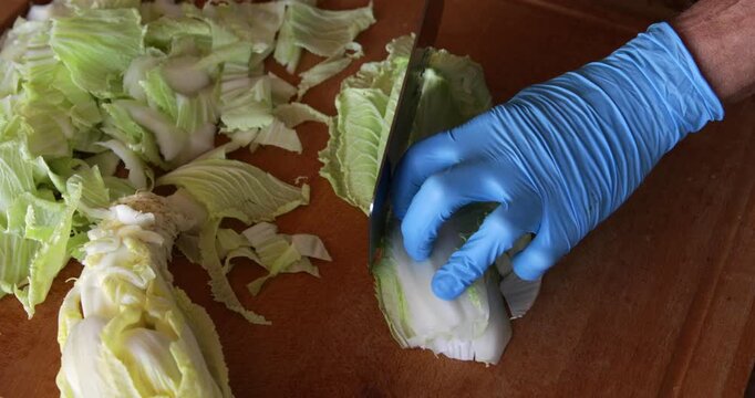 Chinese cabbage bai cai leaves lined up and cut with sharp angle shape using wide Asian style cleaver knife