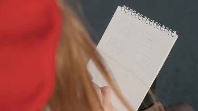 Urban journaling snapshot. Photograph capturing informal writing near metropolitan pavement scene. Unposed image showing personal journaling on spiral pad with city background and sunlight