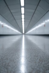 Long, narrow corridor illuminated by bright lights creates sense