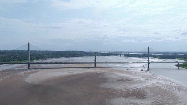 Liverpool, Merseyside, UK, June 19, 2025; Aerial 4K video footage of the Mersey Gateway toll bridge with stunning views over the River Mersey, Liverpool, UK.