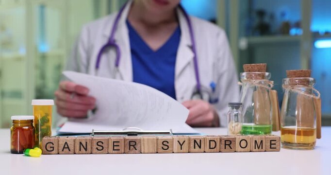 Wooden cubes form medical term Ganser Syndrome on table with medicine. Doctor carefully reviews documents describing reported symptoms of patient