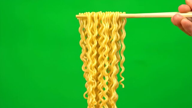 Close-up of cooked instant ramen noodles being lifted with chopsticks, isolated on a chroma key green background. Perfect for food-related projects and compositing.