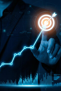 Finger points directly at a glowing target icon at the peak of an upward-trending financial or business growth graph.