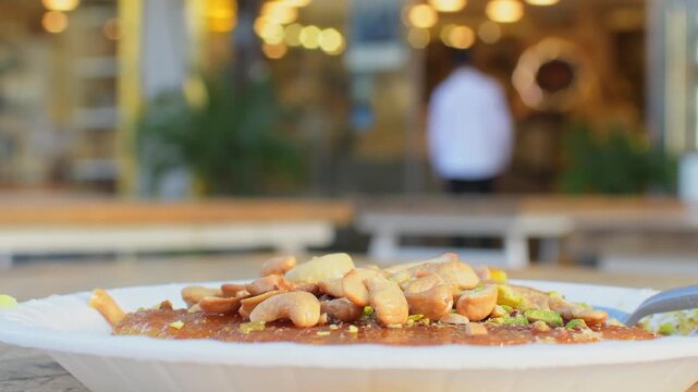 Close up panning view Jordan traditional fresh knafeh dessert with melted cheese semolina crust sugar syrup pistachio cashew topping Middle East street food close up