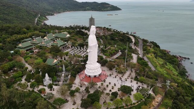 Aerial view of the lady buddha statue at linh ung pagoda in da nang, vietnam with scenic ocean and mountain landscape