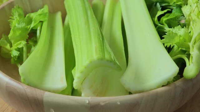 Fresh celery in a wooden bowl.	